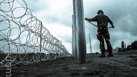 Ungarsk militær lægger pigtråd ud. Foto: Public domain.